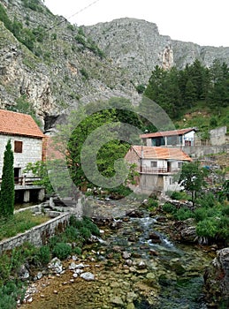 Rocks, houses and Duman, the spring of the Bistrica River in the small town of Livno in Bosnia and Herzegovina