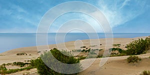 Panoramic view of the sand dunes and blue sky over the sea on a summer morning