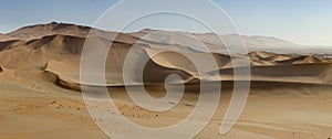 Panoramic view of sand-dunes in the Sossusvlei Nature Reserve in Namibia. These reddish dunes at the main `vlei` salt pan are m