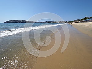 Panoramic view of sandy beach at bay of ACAPULCO city in Mexico with tourists and beautiful waves of Pacific Ocean