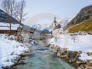 Panoramic view of scenic winter landscape in the Bavarian Alps with famous Parish Church of St. Sebastian in the village of Ramsau