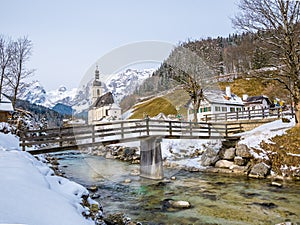 Panoramic view of scenic winter landscape in the Bavarian Alps with famous Parish Church of St. Sebastian in the village of Ramsau