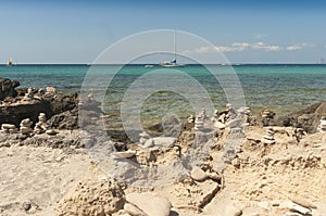 Panoramic view of the sea with boats moored by a beach with sand rock and pyramid stones.