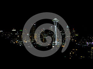 A panoramic view of the Seattle skyline at night, with the Space Needle and other landmarks lit up