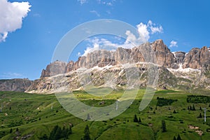 Panoramic view on the Sella massif and Piz Boe. Dolomites, Italy, Beautiful sunny summer day, green hills blue sky Passo Pordoi