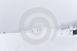 Panoramic view of ski slope on cloudy day during a snowfall
