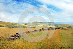 Panoramic view from the slopes of the Terevaka Volcano on Easter Island, showing green vegetation and the ocean against