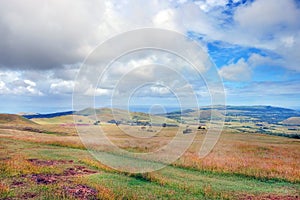 Panoramic view from the slopes of the Terevaka Volcano on Easter Island, showing green vegetation and the ocean against