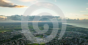 A panoramic view of the small city with the sea on a cloudy summer evening.