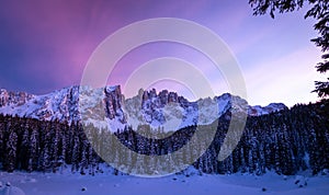 Panoramic view of snow covered lake carezza lago di carezza, karersee and latemar in winter; unesco world heritage, dolomites