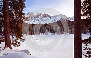 Panoramic view of snow covered lake carezza lago di carezza and latemar in winter; unesco world heritage, dolomites