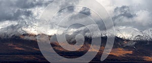 Panoramic view of snow covered mountains with dense low level clouds in Alaska during autumn time photo