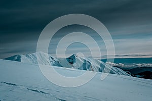 Panoramic view of snow covered mountains  touching the clouds