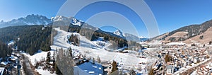 Panoramic view of snow covered mountain and town against clear sky during winter photo