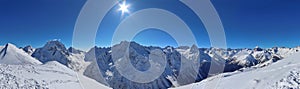 Panoramic view of snowy mountains peaks in the clouds blue sky Caucasus