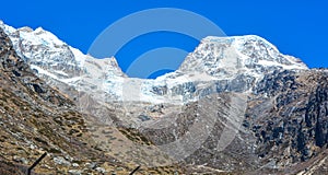 Panoramic view of a snowy mountainside. The glow of the sun illuminates the fall colors, along with the first snow found high up i