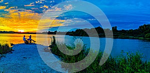 Panoramic view Sports Fishermen at Sunset early fall with beautiful skyline over Ed Zorinsky lake Omaha Nebraska. Water reflection