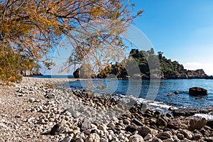 Panoramic view from the stone pebble beach Spiaggia di Isola Bella on touristic paradise island Isola Bella in Taormina, Sicily,