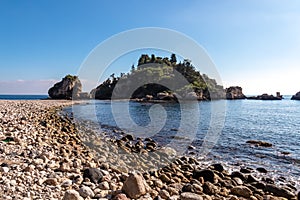 Panoramic view from the stone pebble beach Spiaggia di Isola Bella on touristic paradise island Isola Bella in Taormina, Sicily,