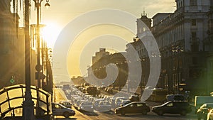 Panoramic view of sunset between the buildings in the city. At the end of the road the sun sets on the horizon