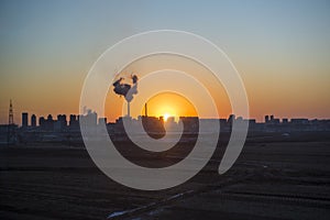 Panoramic view of sunset in the city with silhouette of buildings and industrial factory,pollution city or town concept