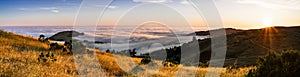 Panoramic view at sunset of valley covered in a sea of clouds in the Santa Cruz mountains, San Francisco bay area, California