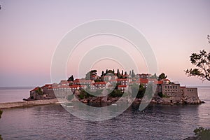 Panoramic view of Sveti Stefan in Montenegro at pink sunset. Famous tourist place near Budva Natural