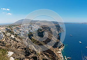 Panoramic view on Thira town and rocky coastline of Santorini island, Greece.