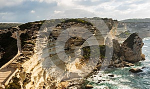 Panoramic view of thr rocky sea shore with clear transparent blue water, cliffs, huge rocks, grass. Bonifacio, Corsica, France