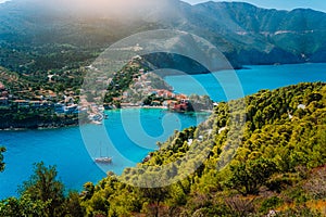 Panoramic view to Assos village Kefalonia. Greece. White lonely yacht in beautiful turquoise colored bay lagoon water