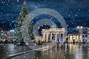 Panoramic view to the famous Brandenburg Gate in Berlin, Germany, with a Christmas tree and snow