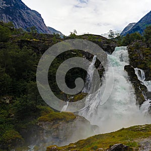 Panoramic view to kleivafossen waterfall at briksdalselva river, Briksdalsbreen glacier, Norway