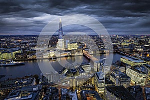 Panoramic view to the lit skyline of London, UK, with modern office buildings during evening time