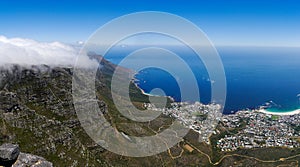 Panoramic view to the south of Table Mountain covered in clouds, below fantastic view of Camps Bay