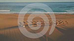 Panoramic view tropical beach ocean surf. Aerial empty recliners and umbrellas