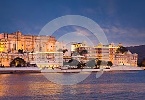 Panoramic view of the Udaipur City Palace at sunset from lake Pichola in Rajasthan, India