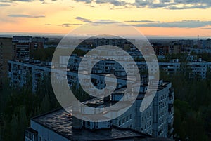 Panoramic view of urban residential areas in the evening twilight against the sunset sky from the height of the 16th floor