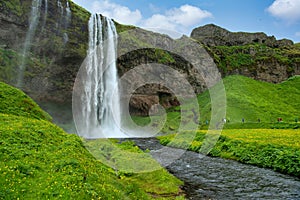 Panoramic view of valley and waterfall Seljalandsfoss in Iceland Many tourists follow the path to see the back of the waterfall