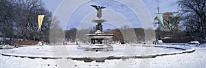 Panoramic view of water fountain covered with fresh winter snow in Central Park, Manhattan, New York City