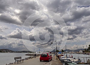 Panoramic view of the waterfront of NEA Artaki on the island of Evia in Greece with a Cycladic-style Church, yachts, fishing boats