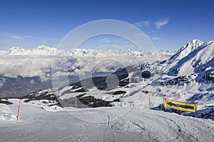 Panoramic view of wide and groomed ski piste in resort of Pila in Valle d`Aosta, Italy during winter