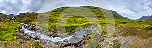 Panoramic view of wilderness of fjord landscape and Selbrekkufoss waterfall near Seydisfjordur on Iceland, summer time