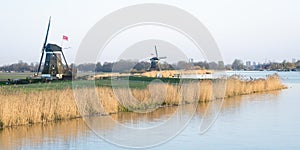 Panoramic view of windmills along a lake in Holland