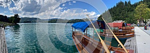 Panoramic view of wooden boats in the harbor at pier on Lake Bled in the Slovenian mountains