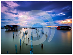 Panoramic view of wooden posts in sea against sky