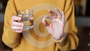 Young woman holding white pills in hands photo