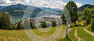 Panoramic view of Zell am See with Zeller Lake in summer. Nature panorama of mountain road, meadows and Tirol Alps in