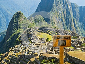 Panoramic viewpoint of the lost Inca city Machu Picchu, with wooden photography sign in foreground, Cusco region, Peru