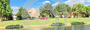 Panoramic waterfront houses with mature bold cypress trees and retaining wall near Dallas