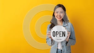 Panoramic wide banner. happy asian pretty woman in casual clothing smiling and hold open sign board with copy space area for text